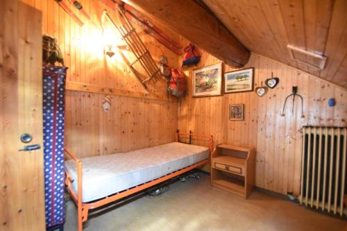 a bedroom with a bed in a wooden cabin at Casa Canale in Tonezza del Cimone