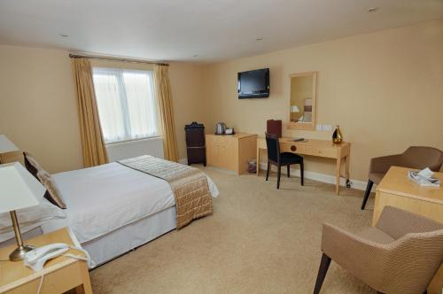 a hotel room with a bed and a desk at The Trouville Bournemouth in Bournemouth