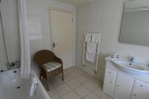 a bathroom with a sink and a tub and a toilet at The Trouville Bournemouth in Bournemouth