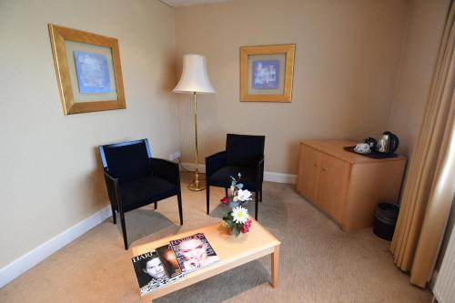 a living room with two chairs and a coffee table at The Trouville Bournemouth in Bournemouth