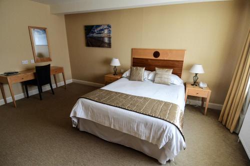 a hotel room with a large bed and a desk at The Trouville Bournemouth in Bournemouth