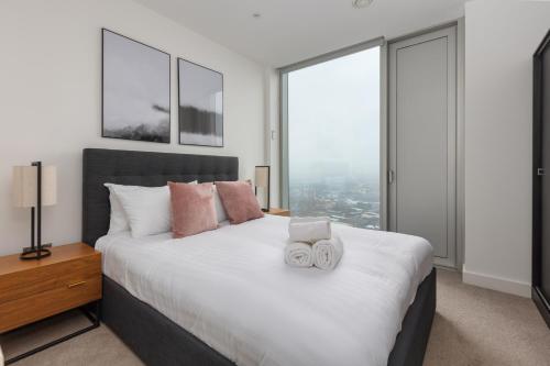 a bedroom with a large white bed with windows at Greengate in Manchester