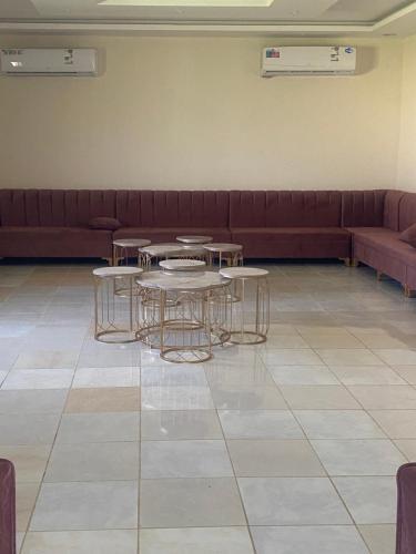 a waiting room with tables and a couch at استراحة الشروق in Al ‘Uqūl