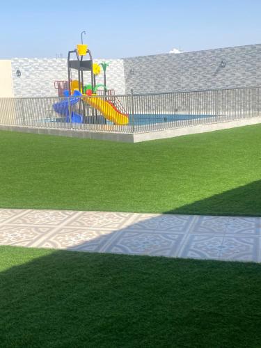 einen Spielplatz mit Spielgeräten in einem Park in der Unterkunft استراحة الشروق in Al ‘Uqūl