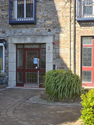 a brick building with a red door and some plants at Gracian OMB Dublin Apartment in Dublin