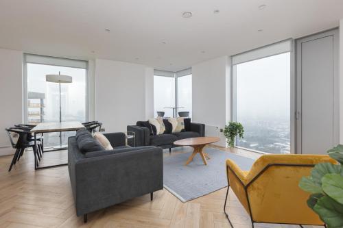 a living room with couches and tables and windows at Greengate in Manchester