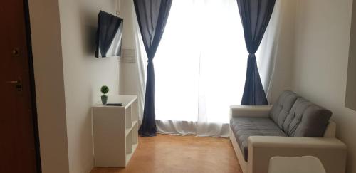 a living room with a couch and a large window at CasaAlma in Serdiana