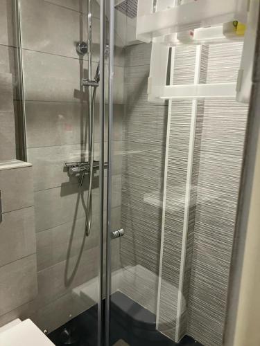 une douche avec une porte vitrée dans une salle de bain dans l'établissement Appartement 4 personnes St-Pierre-la-Mer proche commerces, à Fleury