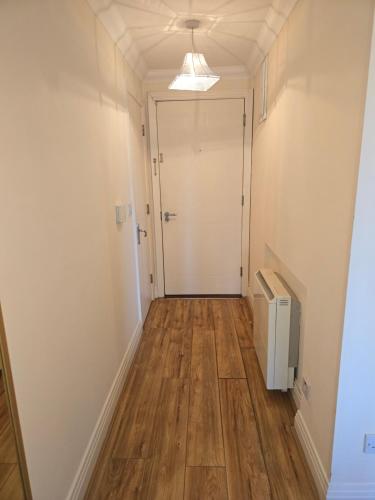 an empty hallway with a door and wooden floors at Gracian OMB Dublin Apartment in Dublin