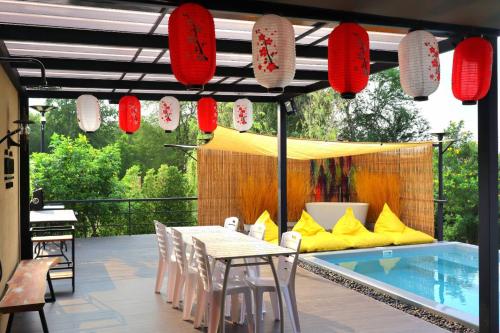 a patio with a table and chairs next to a pool at Morimei Khaoyai in Ban Khlong Yang