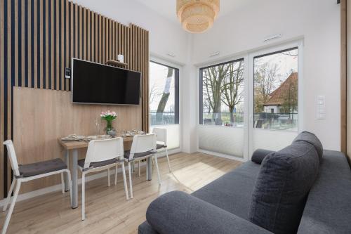 a living room with a couch and a table with chairs at Modern Studio with Terrace and Parking in Swinoujscie in Świnoujście