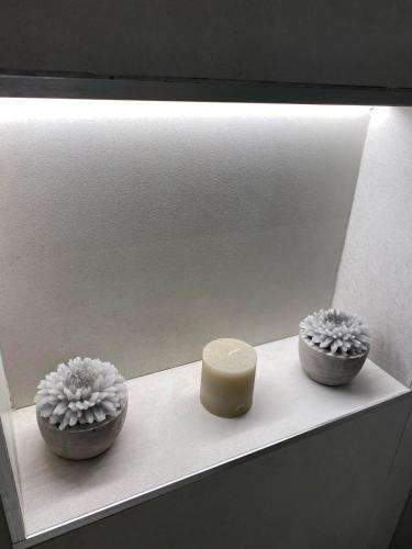 a shelf with two small vases and a candle on it at La Maison de Rosaline Rooms in Barletta