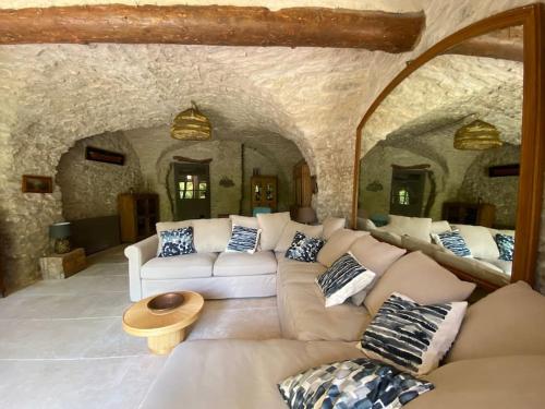 - un salon avec un canapé dans une pièce en pierre dans l'établissement Luberon en Provence - La maison de Michèle au cœur de Goult, à Goult