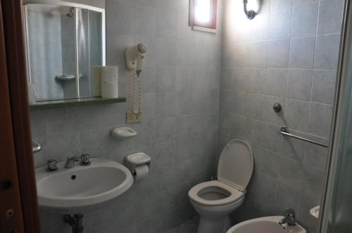 a bathroom with a sink and a toilet and a mirror at Hotel Villa Cimmentorosso in Ischia