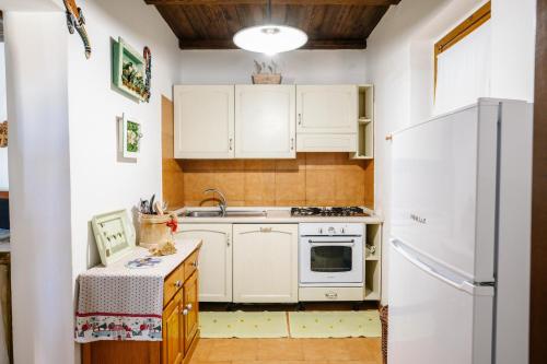a kitchen with white cabinets and a refrigerator at Selvicolle Country House in Crispiero