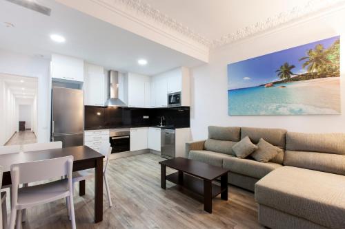 cocina y sala de estar con sofá y mesa en AB Margarit Apartments en Barcelona