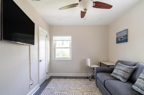 a living room with a couch and a flat screen tv at Delray Oasis: Pool, Gazebo & Beach Access in Delray Beach