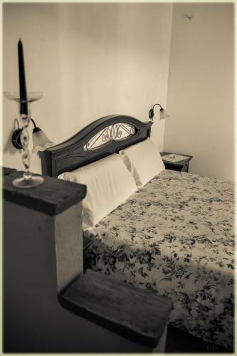 ein Schlafzimmer mit einem Bett mit einem Kreuz darüber in der Unterkunft Il Palazzo del Barone - Dimora storica in Pietrapertosa