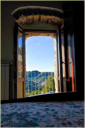 Zimmer mit einem großen Fenster mit Aussicht in der Unterkunft Il Palazzo del Barone - Dimora storica in Pietrapertosa