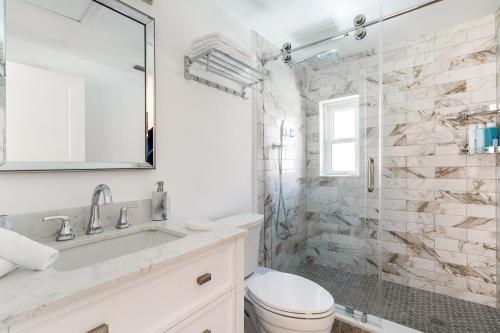 a bathroom with a sink and a toilet and a shower at Delray Oasis: Pool, Gazebo & Beach Access in Delray Beach