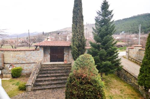 una pequeña casa de piedra con escaleras y árboles en Villa Luxury Paradise Kastoria, en Lithiá