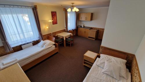 a view of a room with two beds and a kitchen at Pokoje Gościnne Muszyna przy sądzie in Muszyna