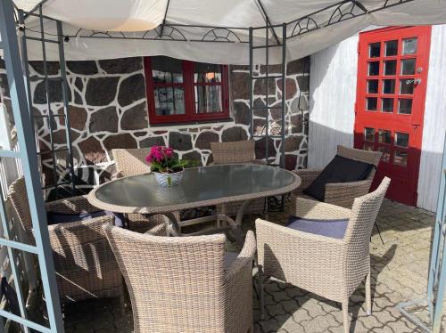 d'une terrasse avec une table, des chaises et une porte rouge. dans l'établissement Keisergården, à Nørre Alslev