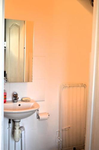 une salle de bain avec un lavabo et un miroir dans l'établissement Le Joffre - studio sur la digue en centre ville, à Arromanches-les-Bains