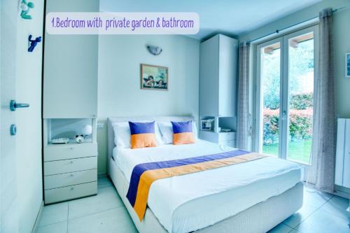 Schlafzimmer mit einem Bett mit blauen Wänden und einem Fenster in der Unterkunft Panorama lake view, pool & garden, 2 bathrooms, kingsize & single-beds, fast Internet in Toscolano-Maderno