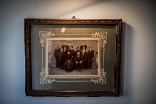 une photo de famille dans un cadre sur un mur dans l'établissement GITES DES ALSACIENNES - loft climatisé dans une maison alsacienne de plus de 400 ans - 2 vélos inclus - WIFI, à Dachstein