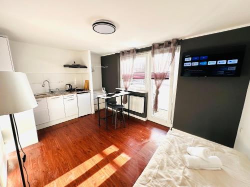 a kitchen with white cabinets and a wooden floor at Keli Apartments Zentrum Oldenburg in Oldenburg