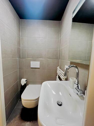 a bathroom with a white sink and a toilet at Keli Apartments Zentrum Oldenburg in Oldenburg