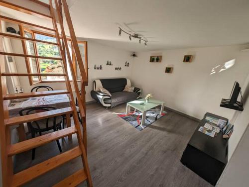 uma sala de estar com uma escada e um sofá em Duplex "La belle vue " em Entrevaux