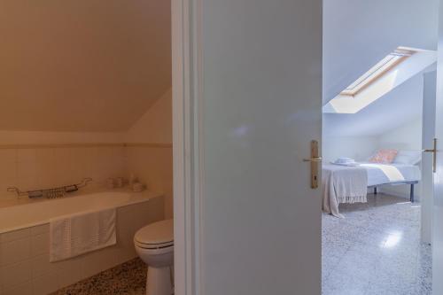 uma casa de banho com um WC, um lavatório e uma cama em Varenna Garden em Varenna