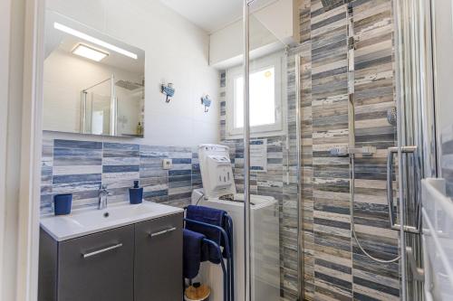 a bathroom with a sink and a glass shower at La Mouette St Philibert 3 étoiles in Saint-Philibert