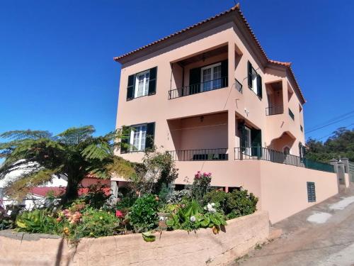 a pink house with flowers in front of it at Abrigo do Monte in Ribeira Brava
