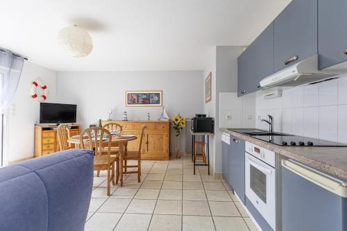 une cuisine et une salle à manger avec une table et des chaises dans l'établissement La Mouette St Philibert 3 étoiles, à Saint-Philibert