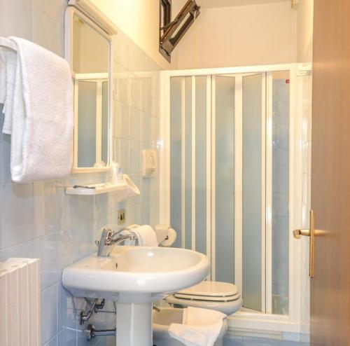 a white bathroom with a sink and a toilet at Garni Onda in Torri del Benaco