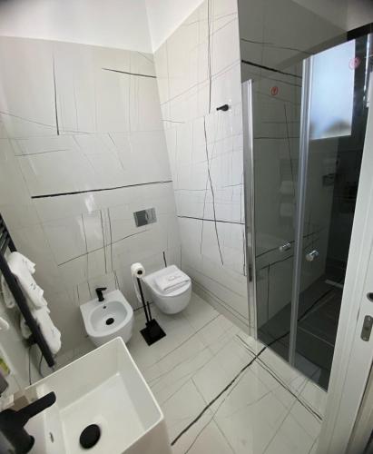 a white bathroom with a toilet and a shower at La Maison de Rosaline Rooms in Barletta