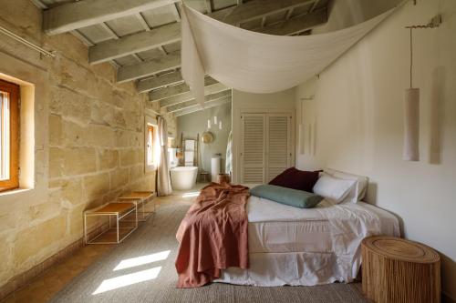 - une chambre avec un lit et une couverture dans l'établissement Amagatay Menorca, à Alaior