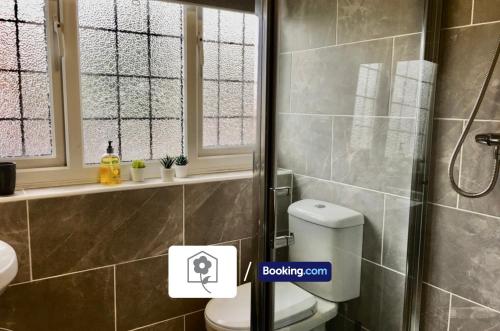 a bathroom with a toilet and a shower with a window at Spacious Detached Highfield House By Your Stay Solutions Short Lets & Serviced Accommodation Southampton Free Parking in Southampton