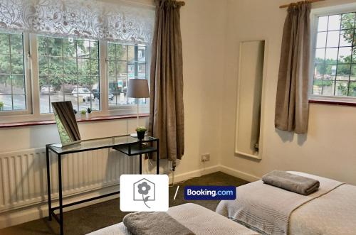a room with a bed and a desk and windows at Spacious Detached Highfield House By Your Stay Solutions Short Lets & Serviced Accommodation Southampton Free Parking in Southampton