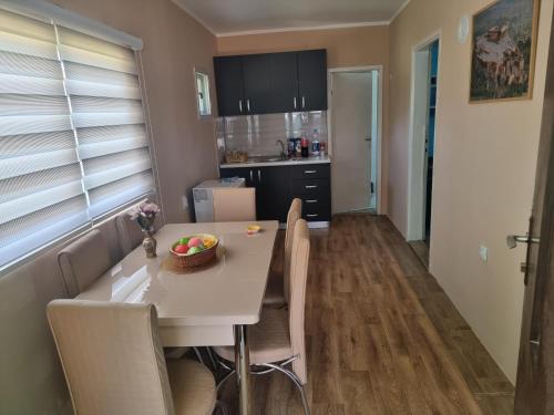 a kitchen and dining room with a white table and chairs at Miris prirode in Vrdnik