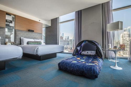 um quarto de hotel com duas camas e um carrinho de bebé em Aloft Chicago Downtown River North em Chicago