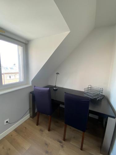 a room with a desk and two blue chairs at 2 chambres Hyper centre avec place de Parking et WIFI in Amiens