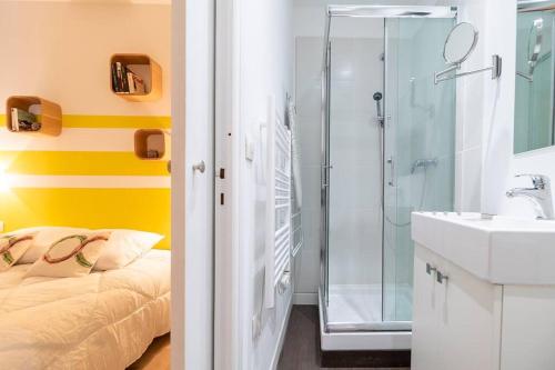 une salle de bain avec une douche, un lit et un lavabo dans l'établissement L'Acapulco, Charmant T1, Clim, Place Comédie, à Montpellier
