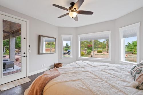 a bedroom with a ceiling fan and windows at Expansive Mesa Retreat with Private Outdoor Pool! in Mesa