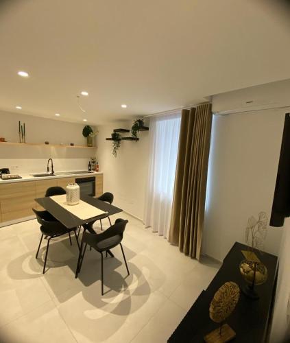 a kitchen and living room with a table and chairs at La Maison de Rosaline Rooms in Barletta