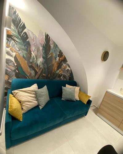 a blue couch in a room with a mural at La Maison de Rosaline Rooms in Barletta