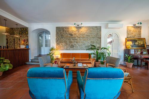 a living room with blue chairs and a table at Giardini Penelope Resort e Spa in Ciampino